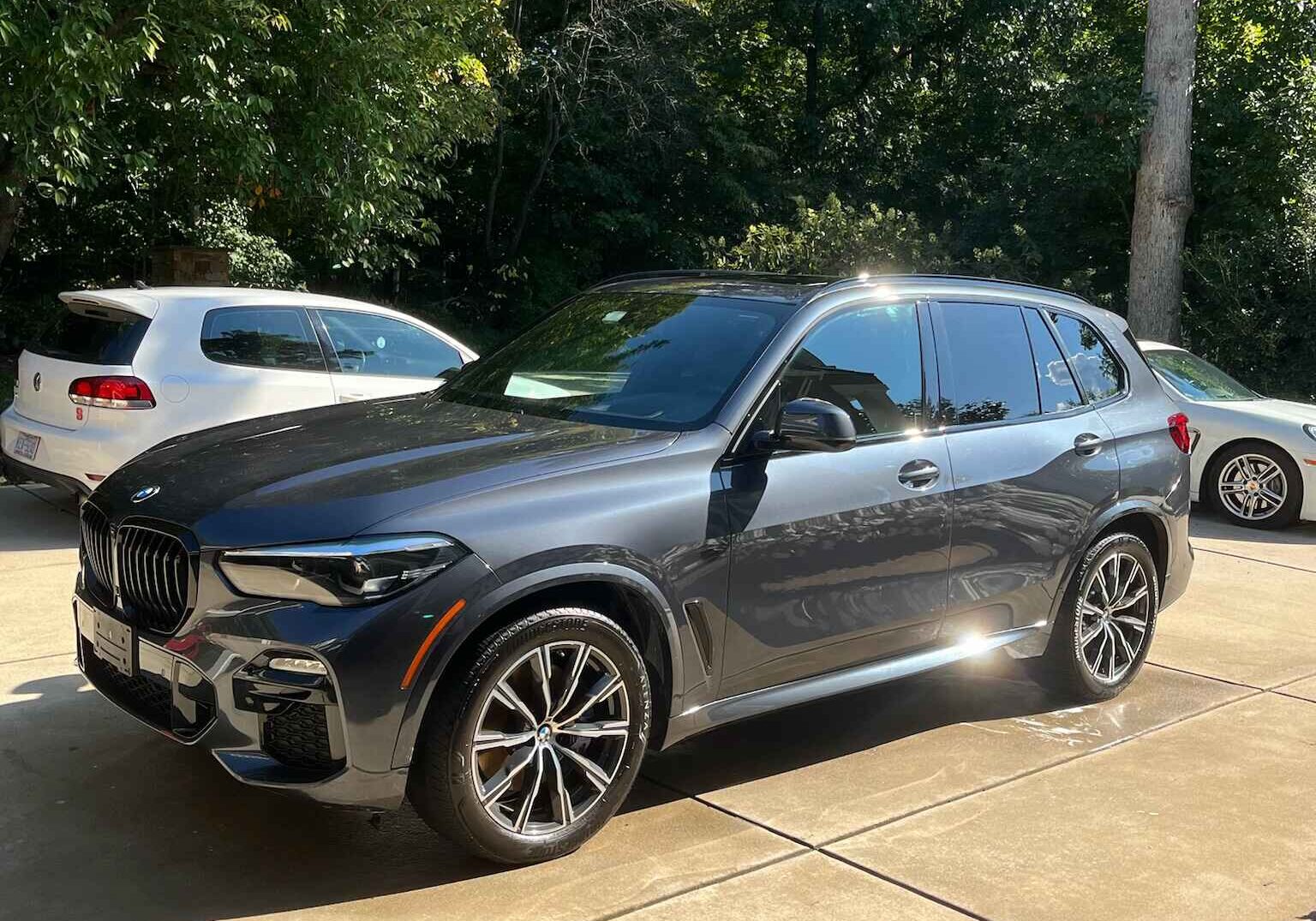 Shiny black BMW SUV in a driveway, reflecting the results of expert ceramic coating and car detailing in Lake Norman.