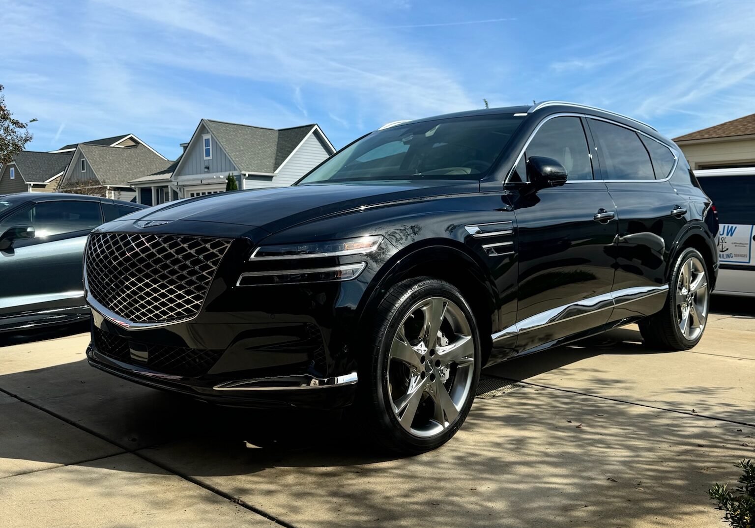 Black Genesis SUV on a residential driveway, showcasing professional Car Detailing near me.